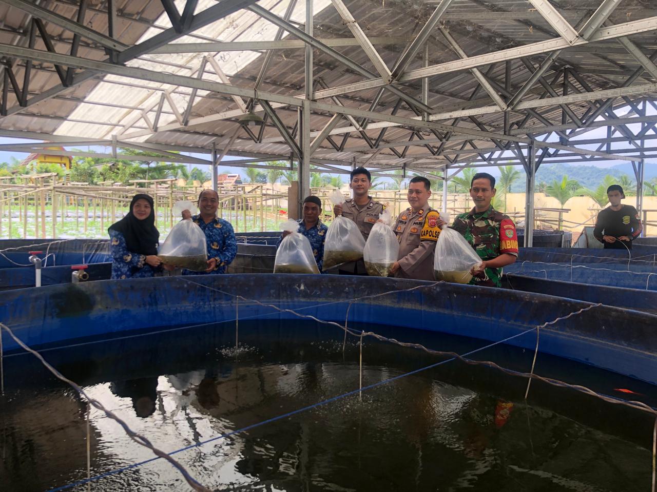 KOMPAK: Kepala UPTD Balai Benih Ikan Dinas Perikanan Kabupaten Sukabumi, Iin Lidinilah, bersama Kepala Desa Kebonpedes, Dadan Apriandani, serta Babinsa dan Bhabinkamtibmas, saat hendak menebar benih ikan nila di kolam bioflok Balesawala, Desa Kebonpedes.(FOTO: DENDI/RADAR SUKABUMI)