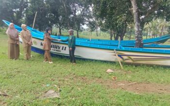Kepala Dinas Perikanan Kabupaten Sukabumi menyerahkan bantuan perahu kepada nelayan.(FOTO: NANDI / RADARSUKABUMI)