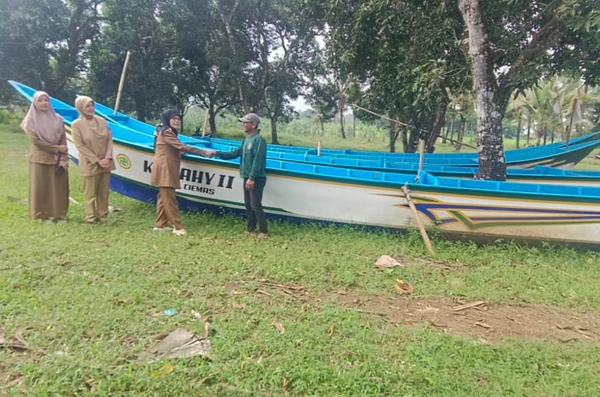 Kepala Dinas Perikanan Kabupaten Sukabumi menyerahkan bantuan perahu kepada nelayan.(FOTO: NANDI / RADARSUKABUMI)