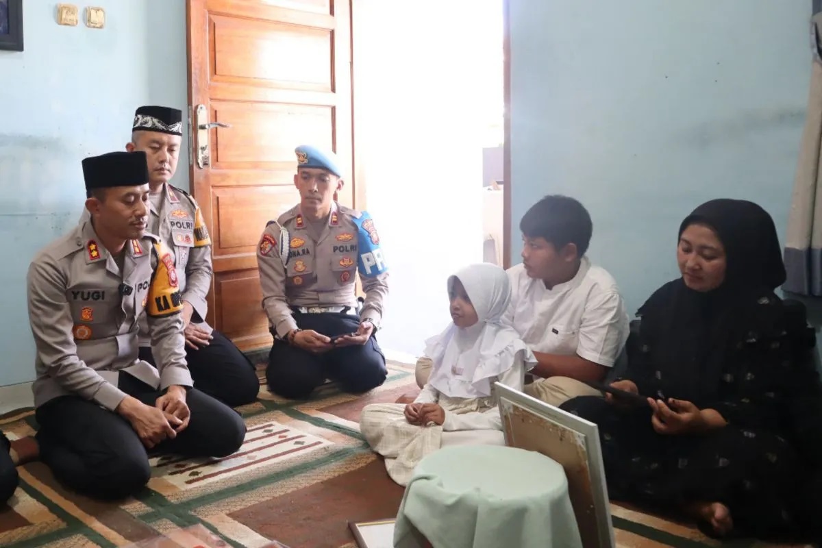Kepala Kepolisian Resor Garut AKBP Yugi Bayu Hendarto saat menyerahkan Surat Keputusan Kenaikan Pangkat Anumerta Almarhum Aipda Cecep Saepul Bahri kepala keluarga almarhum di rumah duka Perum Guntur Residence, Garut Kota, Kabupaten Garut, Jawa Barat, Sabtu (19/7/2025). (Polres Garut)