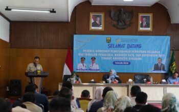 SAMBUTAN : Kepala DPPKB Kabupaten Sukabumi Uus Pirdaus, saat memberikan sambutan pada Workshop Pemutakhiran Pendataan Keluarga 2025 di Aula Gedung Pendopo Sukabumi.(FOTO : DENDI/RADAR SUKABUMI)