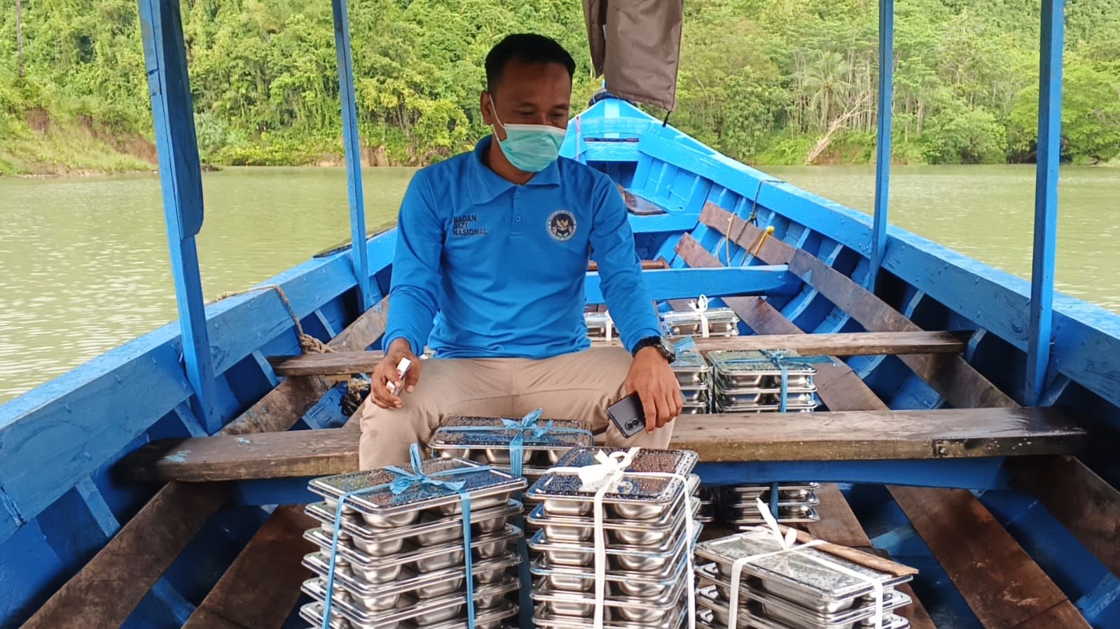 BERJUANG : Salah satu petugas SPPG dari Kecamatan Cibitung, tengah berjuang menyalurkan makanan bergizi dengan menyusuri derasnya aliran Sungai Cikaso menggunakan perahu motor kecil.