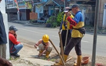 MEMBERSIHKAN: Personel DPUTR Kota Sukabumi saat menangani saluran drainase tersumbat di Jalan Cemerlang, Kelurahan Sukakarya.