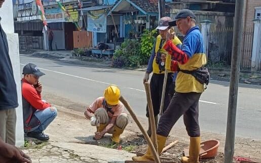 MEMBERSIHKAN: Personel DPUTR Kota Sukabumi saat menangani saluran drainase tersumbat di Jalan Cemerlang, Kelurahan Sukakarya.