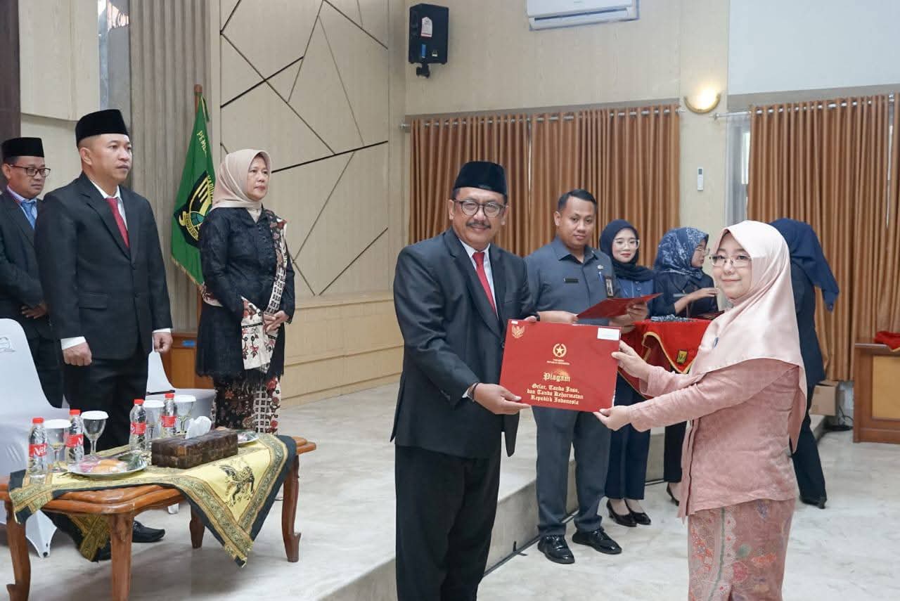 Bupati Sukabumi Asep Japar saat menyerahkan penghargaan kepada PNS.(FOTO: NANDI / RADARSUKABUMI)