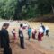 MEMBAHAYAKAN: Sejumlah warga dan anak anak sekolah saat melintasi sungai akibat jembatan hanyut. (Foto: ist)