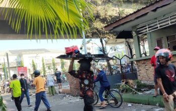 Sejumlah orang menbawa barang hasil jarahan usai Kantor DPRD Makassar dibakar massa, di Jalan Andi Pangeran Pettarani, Makassar, Sulawesi Selatan, Sabtu (30/8/2025). (Darwin Fatir)