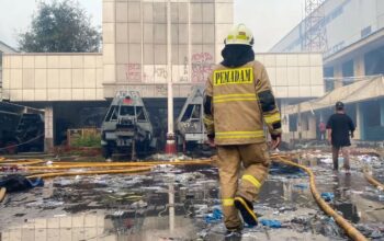 Seorang pemadam kebakaran sedang memasuki Gedung Gegana yang berlokasi di Kramat Raya, Jakarta Pusat, Minggu (31/8/2025). (Chairul Rohman)