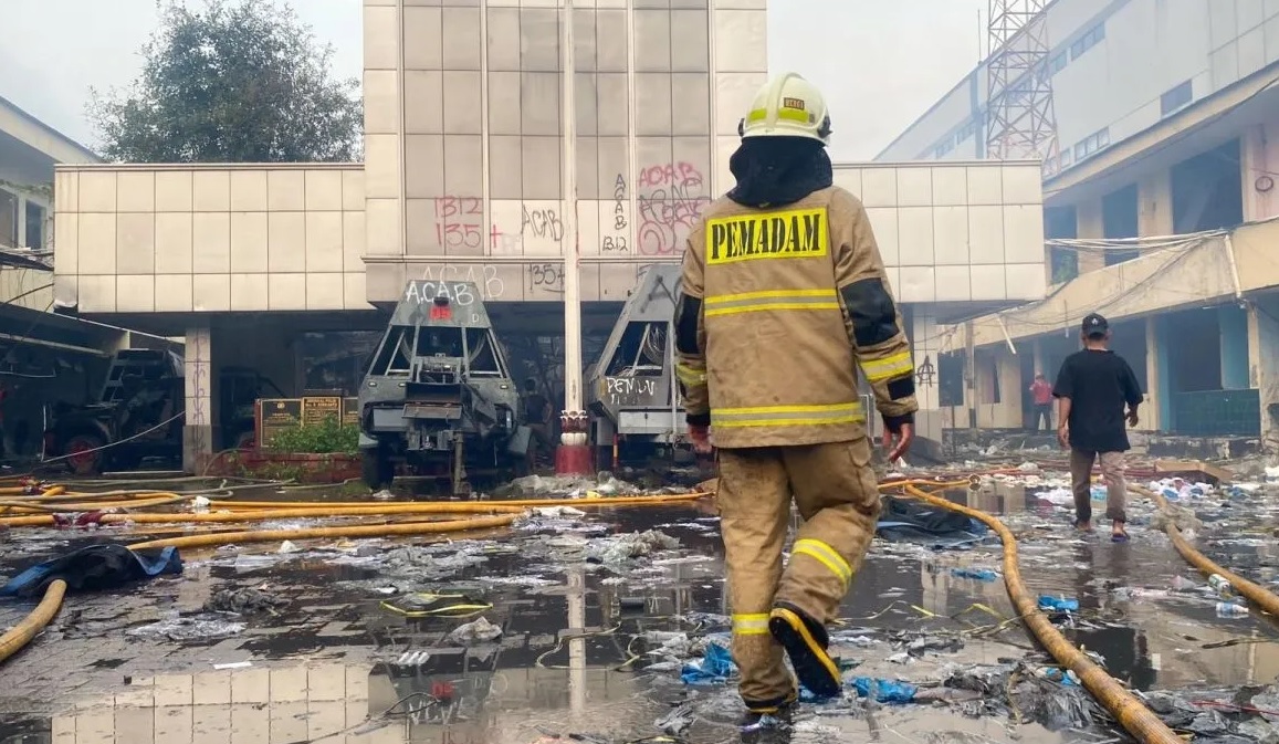 Seorang pemadam kebakaran sedang memasuki Gedung Gegana yang berlokasi di Kramat Raya, Jakarta Pusat, Minggu (31/8/2025). (Chairul Rohman)