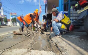 DIBONGKAR : Petugas gabungan saat membongkar coran yang menutup saluran drainase di Jalan Raya Nasional Siliwangi, Kampung Kebon Cau, RT 02/RW 02, Kelurahan Cicurug, Kecamatan Cicurug, Kabupaten Sukabumi.
