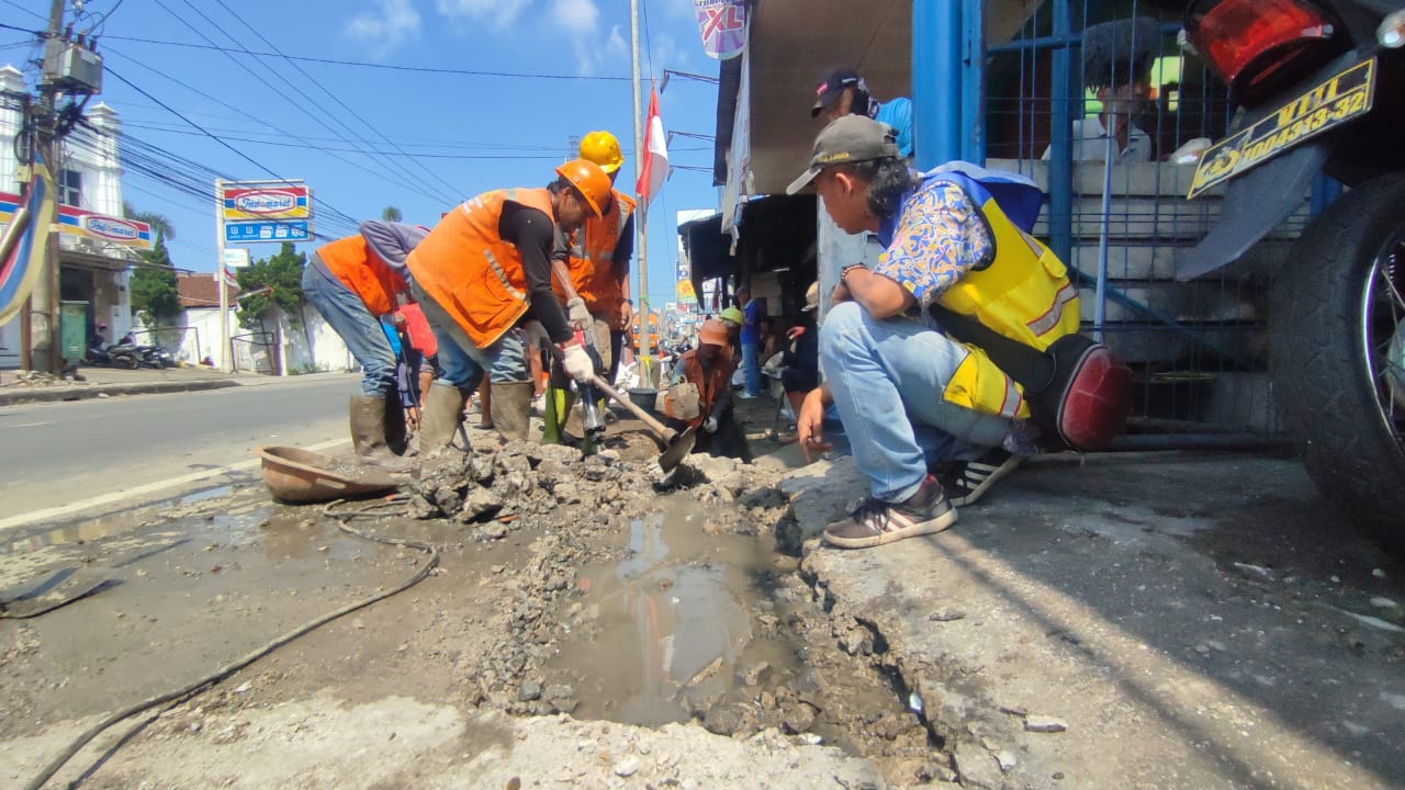 DIBONGKAR : Petugas gabungan saat membongkar coran yang menutup saluran drainase di Jalan Raya Nasional Siliwangi, Kampung Kebon Cau, RT 02/RW 02, Kelurahan Cicurug, Kecamatan Cicurug, Kabupaten Sukabumi.