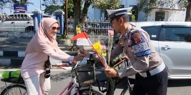 PEMBAGIAN BUKET: Anggota Satlantas Polres Sukabumi Kota membagikan buket bunga kepada pengendara.(FT: IST)