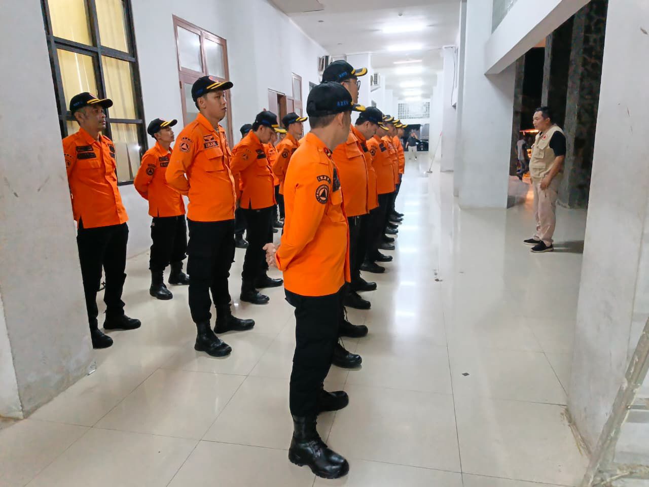 Kalak BPBD Kabupaten Sukabumi, Deden Sumpena, memberikan arahan kepada jajarannya sebelum pawai obor malam.