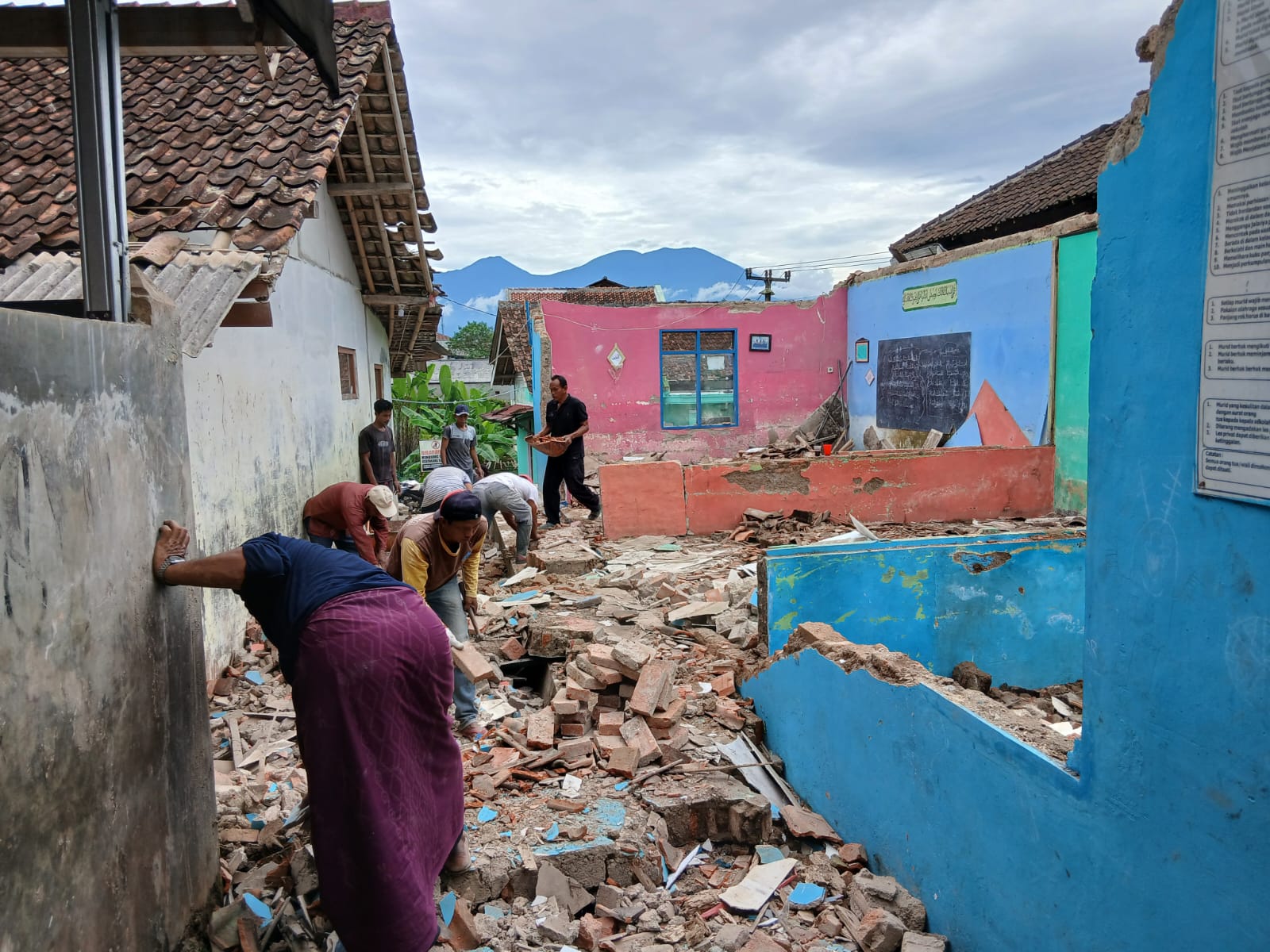 AMBRUK : Warga saat gotong royong membersihkan meterial bangunan sekolah ambruk di MD Nurul Hikmah di Kampung Ciburial, Desa Gunungguruh, Kecamatan Gunungguruh, Kabupaten Sukabumi, pada Rabu (20/8).