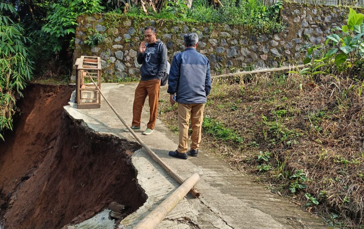 DITINJAU : Petugas Kecamatan Sukaraja, saat meninjau longsor yang merusak akses jalan di Kampung Bunut, RT 007/002, Desa Limbangan, Kecamatan Sukaraja.