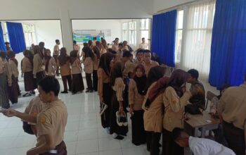 DILAYANI : Siswa SMKN 1 Gunungguruh, saat antre hendak melakukan pengecekan kesehatan gratis.