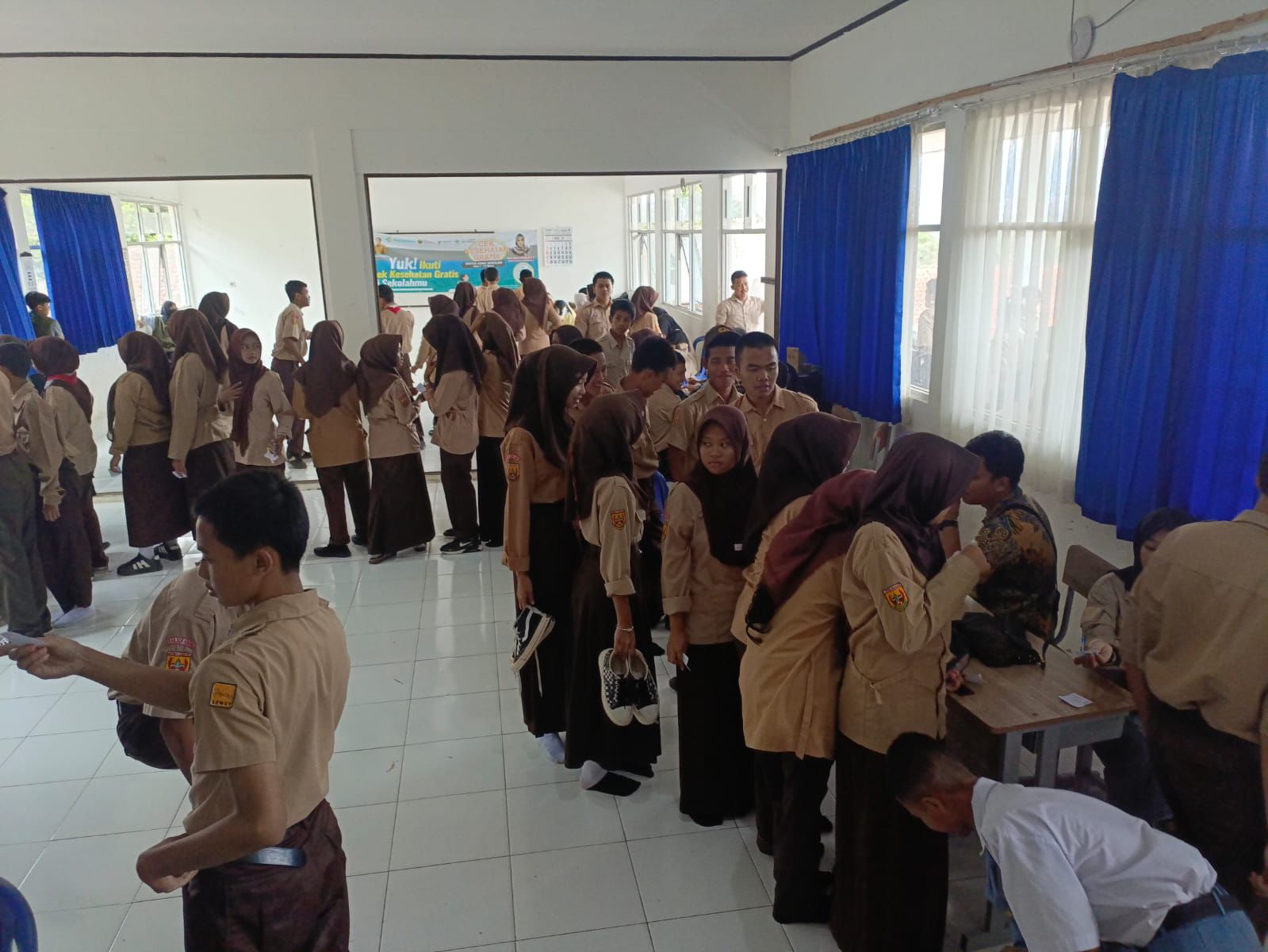 DILAYANI : Siswa SMKN 1 Gunungguruh, saat antre hendak melakukan pengecekan kesehatan gratis.