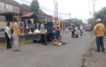 Personel Unit Pelaksana Teknis Daerah (UPTD) Pekerjaan Umum (PU) Wilayah Jampangkulon, Kabupaten Sukabumi saat melakukan upaya perbaikan jalan
