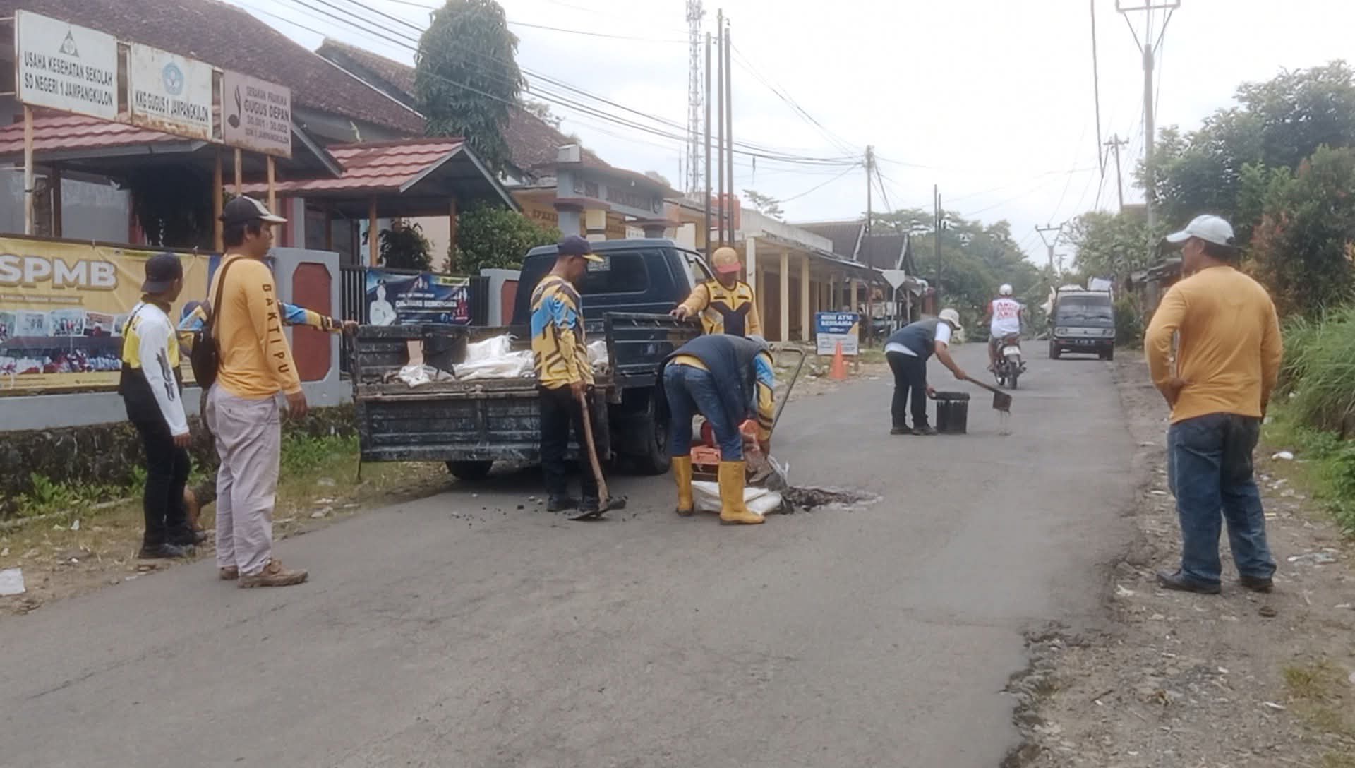 Personel Unit Pelaksana Teknis Daerah (UPTD) Pekerjaan Umum (PU) Wilayah Jampangkulon, Kabupaten Sukabumi saat melakukan upaya perbaikan jalan
