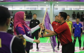 ANC JABO : Group Head Region Jabo XLSMART, Rd. Sofia Purbayanti (kiri) menyerahkan Bendera AXIS kepada wasit Utama atau Referee dalam preliminary Bekasi AXIS Nation Cup 2025 (12/9).