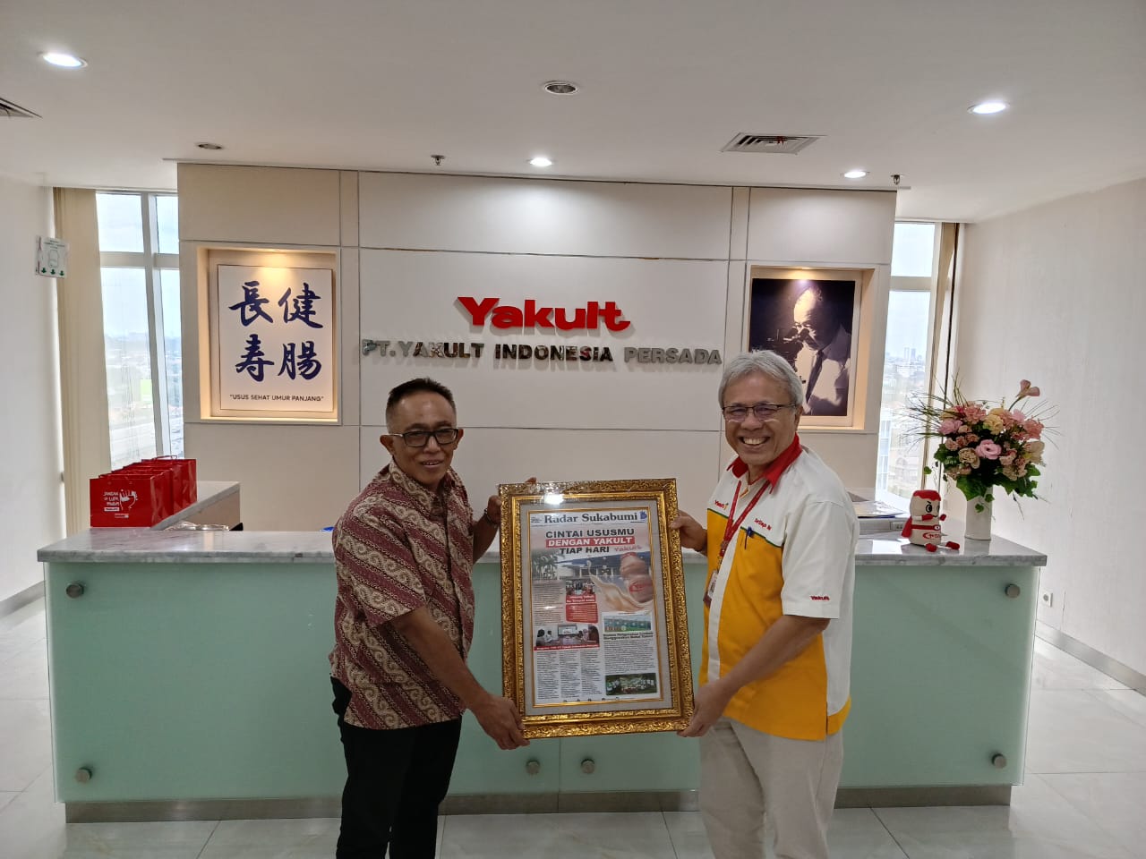 KENANG-KENANGAN : General Manager Radar Sukabumi, Rahmad Yanadi saat memberikan kenang-kenangan kepada Antonius Nababan Senior Director PT Yakult Indonesia Persada
