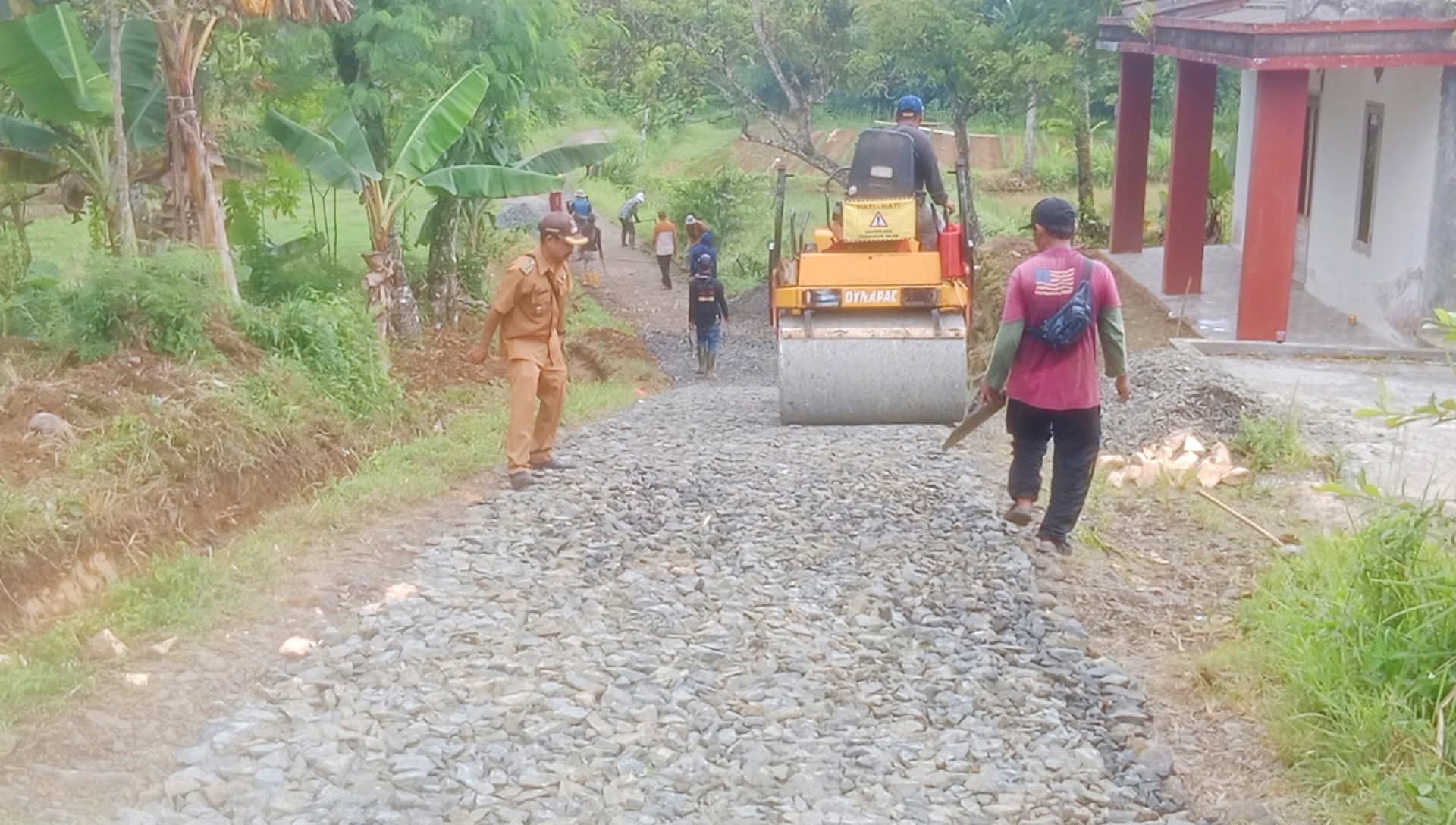 Kepala Desa Padajaya saat meninjau lokasi pengerjaan pengaspalan jalan desa.
