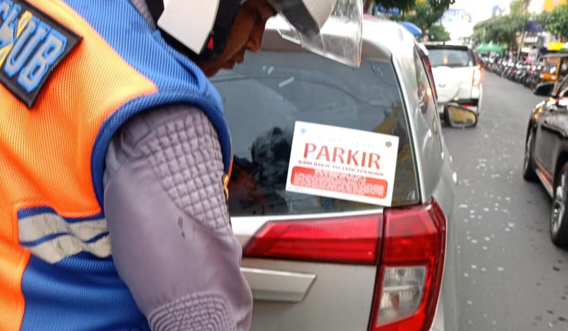 PENERTIBAN: Sejumlah petugas Dishub Kota Sukabumi saat memasang stiker larangan parkir sembarangan di Jalan Jenderal Ahmad Yani, Selasa (21/10).