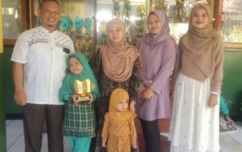 BANGGA: Kepala SDN Pakujajar CBM Sugianto, Husna, sang ibu, wali kelas 2 dan Wakil Kepala Bidang Kesiswaan SDN Pakujajar CBM berfoto bersama sambil menunjukan piala lantaran telah meraih juara 5 besar tingkat nasional lomba Cerdas Mengulas Buku. (widi/radarsukabumi)