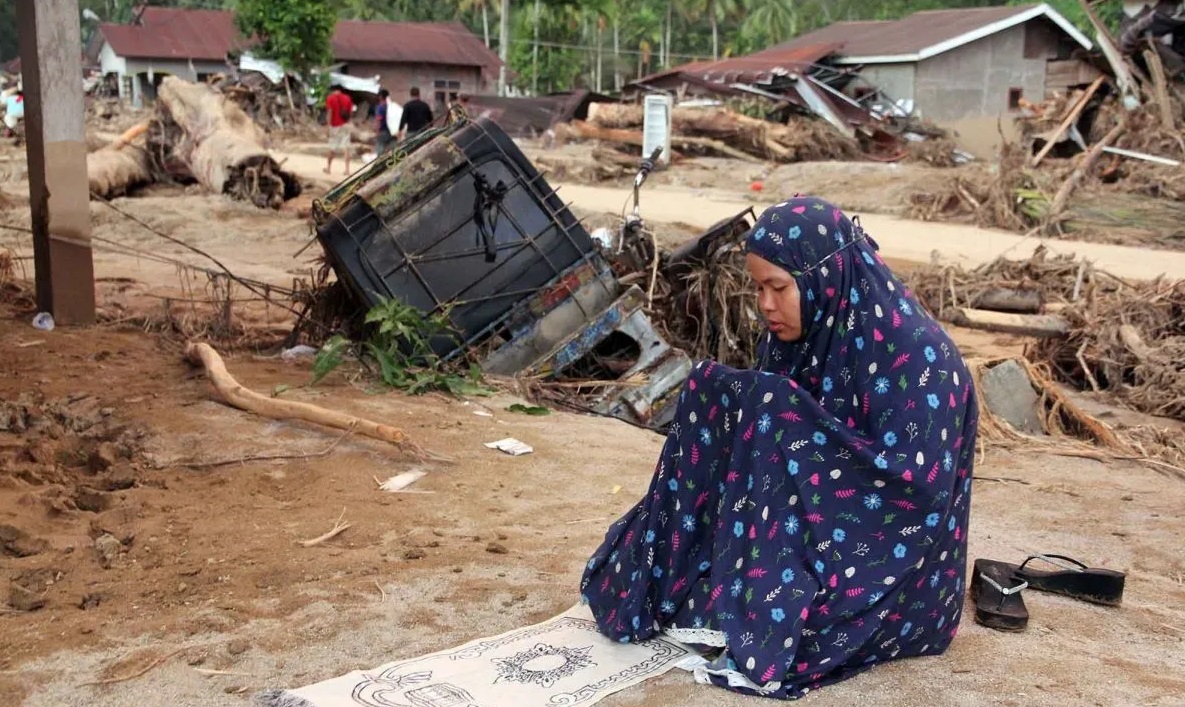 Warga menunaikan shalat di area rumah yang rusak akibat banjir bandang di Desa Aek Garoga, Kecamatan Batang Toru, Kabupaten Tapanuli Selatan, Sumatera Utara, Minggu (30/11/2025). Bencana banjir bandang yang terjadi pada Selasa (25/11) lalu menyebabkan rumah warga rusak, kendaraan hancur, jalan dan jembatan putus.(ANTARA FOTO)