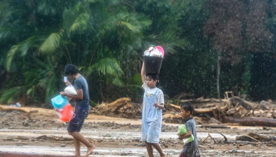Warga korban bencana banjir dan tanah longsor membawa bantuan di Kelurahan Huta Nabolon, Kecamatan Tukka,Tapanuli Tengah, Sumatera Utara, Minggu (7/12/2025). 