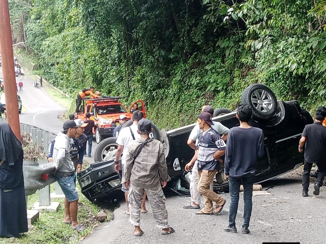 Tim gabungan saat mengevakuasi mobil terbalik di Tanjakan Cisarakan, Citepus, Palabuhanratu.(Nandi/Radar Sukabumi)