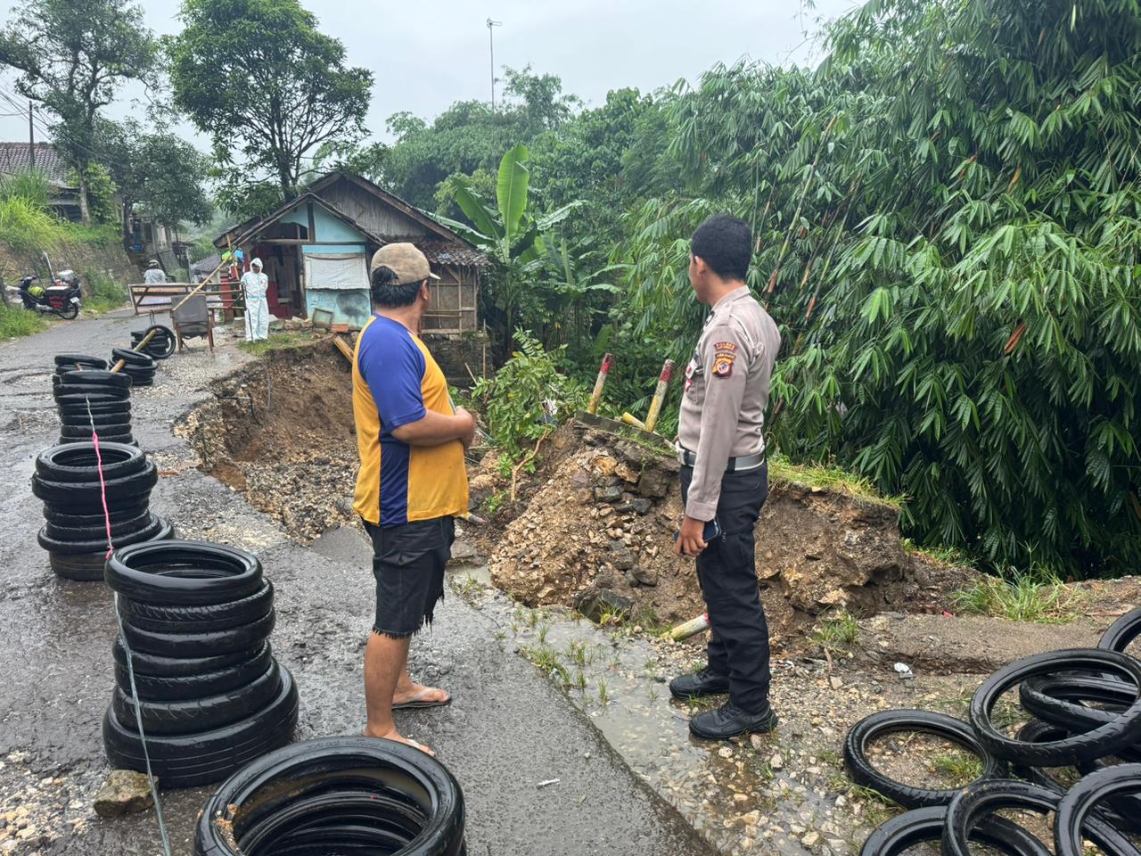 DITINJAU : Petugas Polsek Cibadak bersama warga saat meninjau lokasi longsor yang mengakibatkan jalan penghubung dua desa di Kecamatan Cibadak, nyaris putus pada Kamis (04/12) sore.