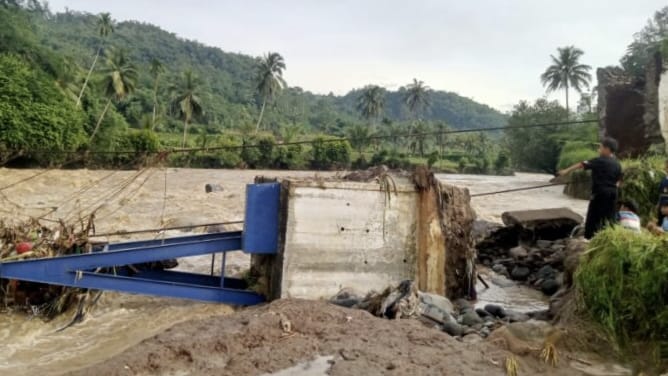 Hujan deras yang mengguyur wilayah Kecamatan Jampangtengah, Kabupaten Sukabumi, pada Minggu malam (28/12/2025) menyebabkan jembatan penghubung menuju Dusun Leuwidingding, Desa Tanjungsari, putus diterjang banjir