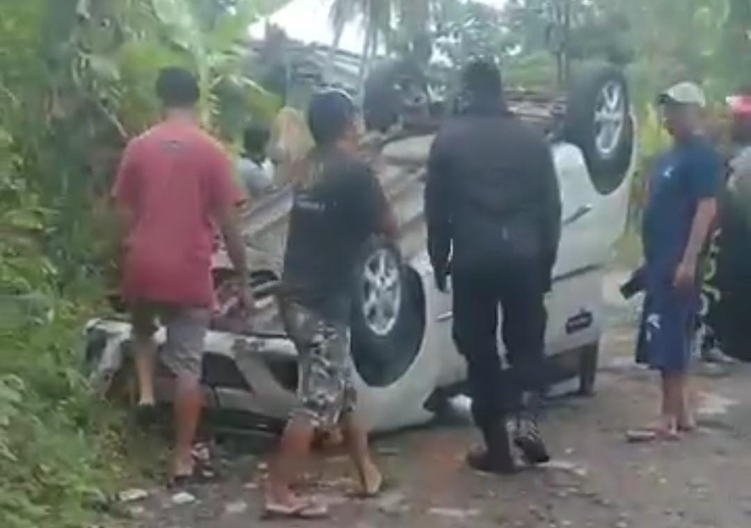 DIEVAKUASI: Warga saat mengevakuasi mobil Daihatsu Ayla yang terbalik di Jalan Raya Cipetir, Desa Kadudampit, Kecamatan Kadudampit, Kabupaten Sukabumi, Kamis (8/1) pagi.