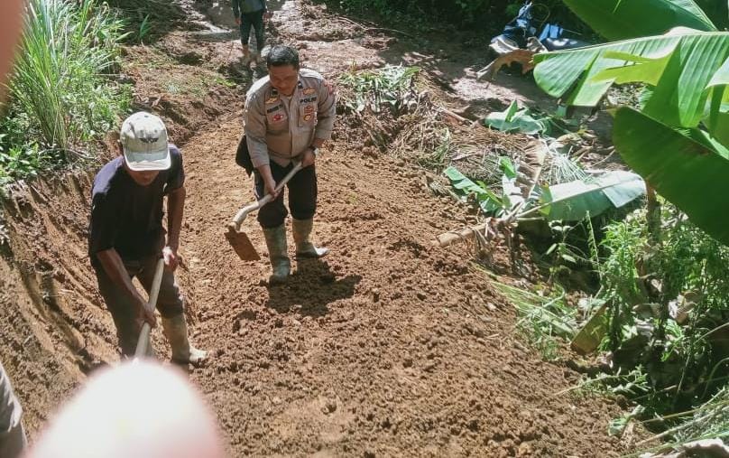 Jajaran Polsek Simpenan bersama warga Desa Sangrawayang, Kecamatan Simpenan, Kabupaten Sukabumi, bergotong royong membuka akses jalan darurat yang terisolir akibat longsor, Sabtu (17/1/2026).
