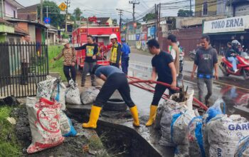 DIPERBAIKI : Petugas gabungan saat memperbaiki saluran drainase Jalan Nasional, di wilayah Kecamatan Parungkuda, Kabupaten Sukabumi.
