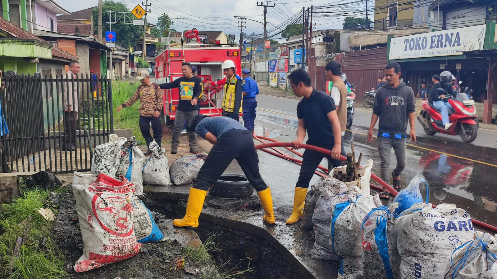 DIPERBAIKI : Petugas gabungan saat memperbaiki saluran drainase Jalan Nasional, di wilayah Kecamatan Parungkuda, Kabupaten Sukabumi.