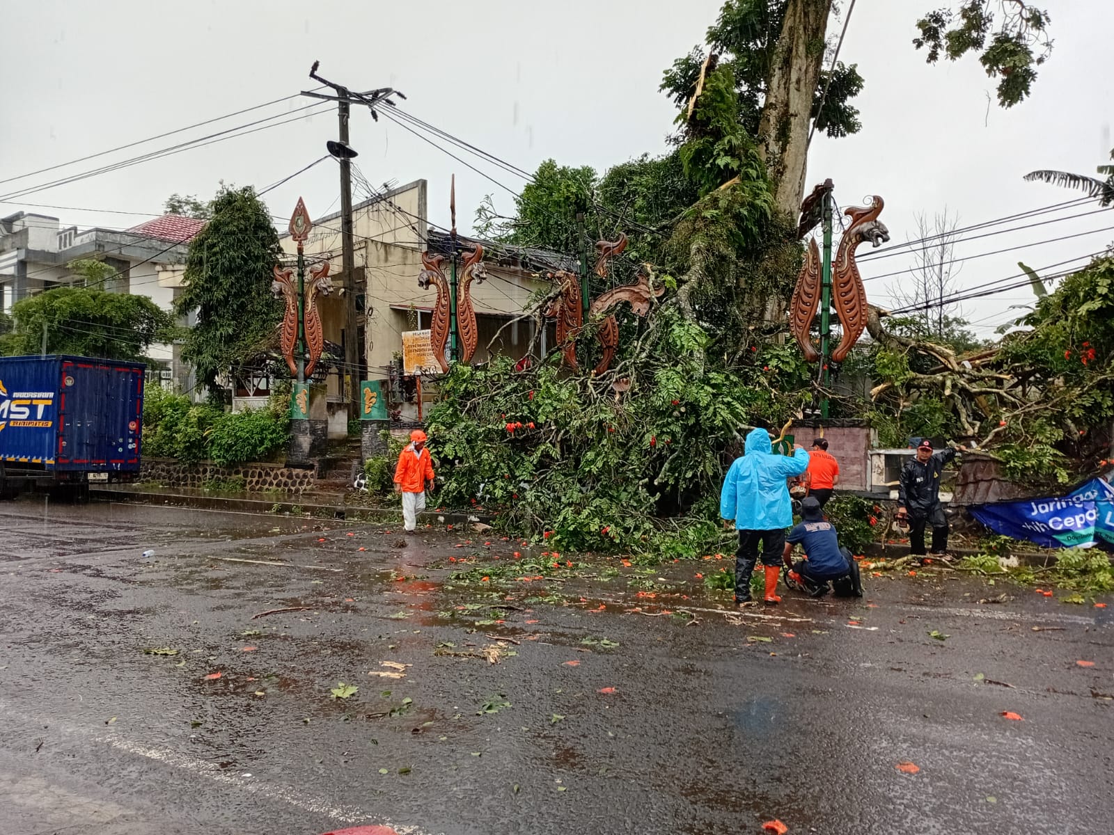 PENANGANAN: Sejumlah personel BPBD Kota Sukabumi saat melakukan penanganan pohon tumbang di samping Kantor Kelurahan Cimundul, Kecamatan Lembursitu, Minggu (11/1).