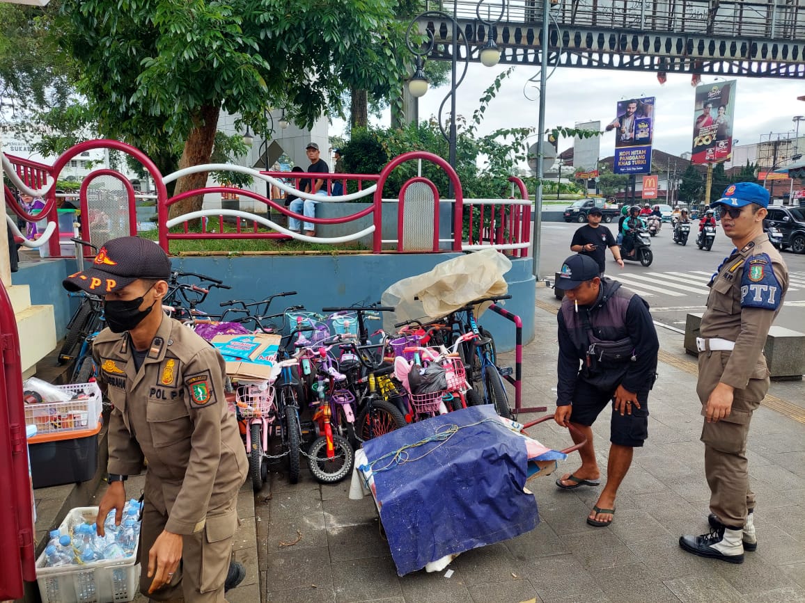 FT: BAMBANG/RADARSUKABUMI PENERTIBAN: Sejumlah personel Satpol PP Kota Sukabumi saat melakukan penertiban pedagang dan penyewaan sepeda di area Lapang Merdeka, Selasa (13/1).