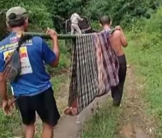 Di atas tandu bambu, seorang ibu bertaruh nyawa. Bayinya tak terselamatkan karena ambulans terhalang jalan rusak. Infrastruktur bukan sekadar akses, tapi soal hidup dan mati.