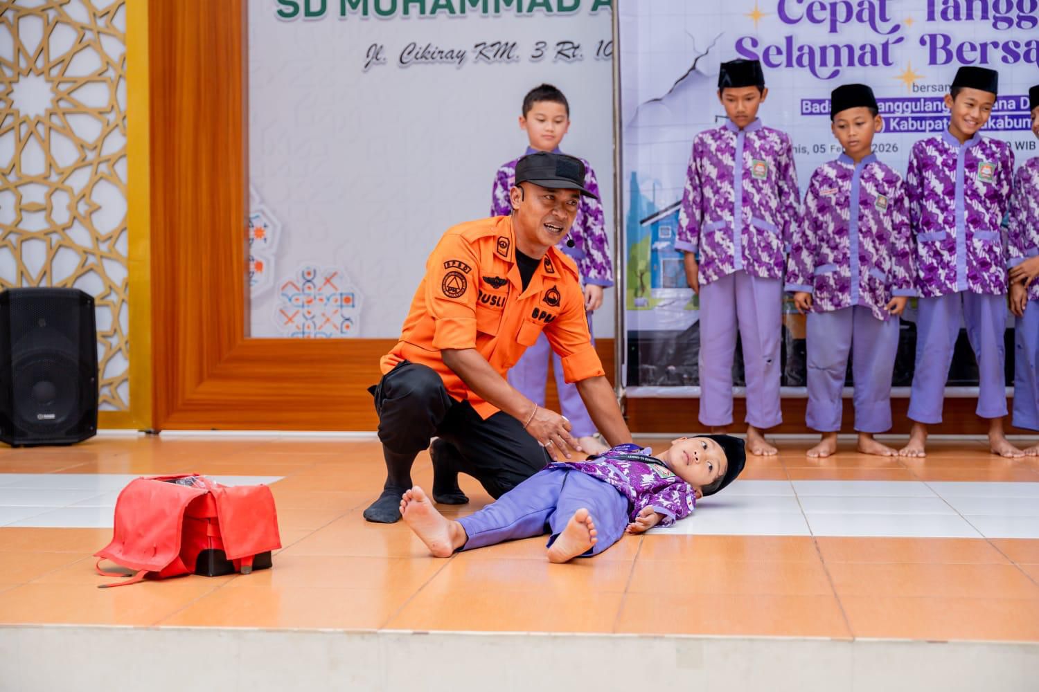 Petugas BPBD Kabupaten Sukabumi memberikan edukasi simulasi bencana alam kepada siswa SD Muhammad Al-Unaizy. Program ini bertujuan memperkuat kesiapsiagaan sekolah menghadapi potensi gempa bumi.