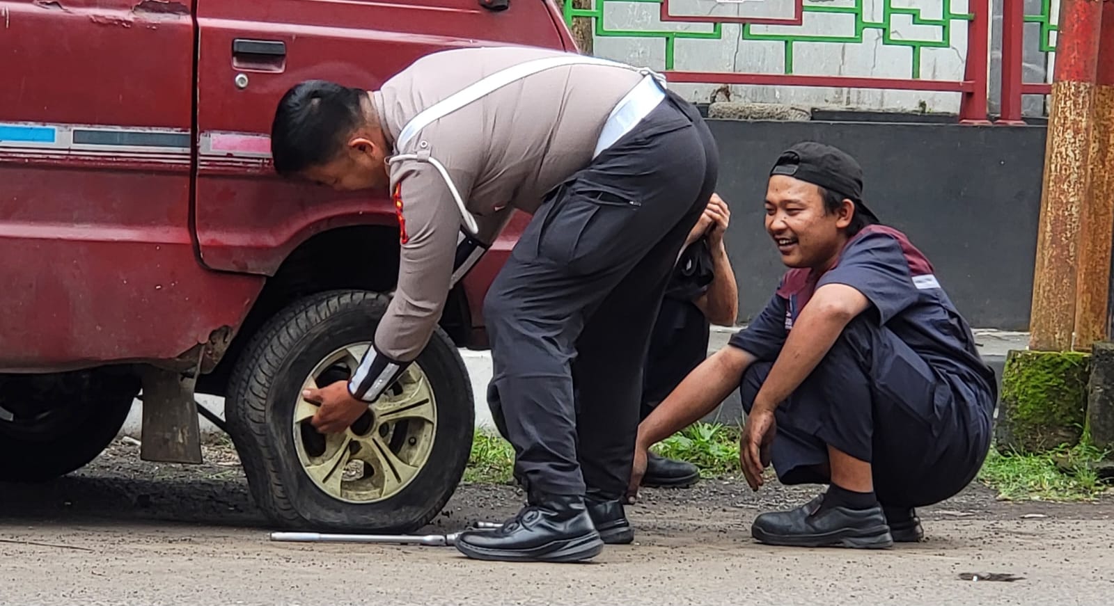 Satlantas Polres Sukabumi Kota sigap membantu pengendara ganti ban bocor di Jalan Pajagalan, menjaga arus lalu lintas tetap lancar.