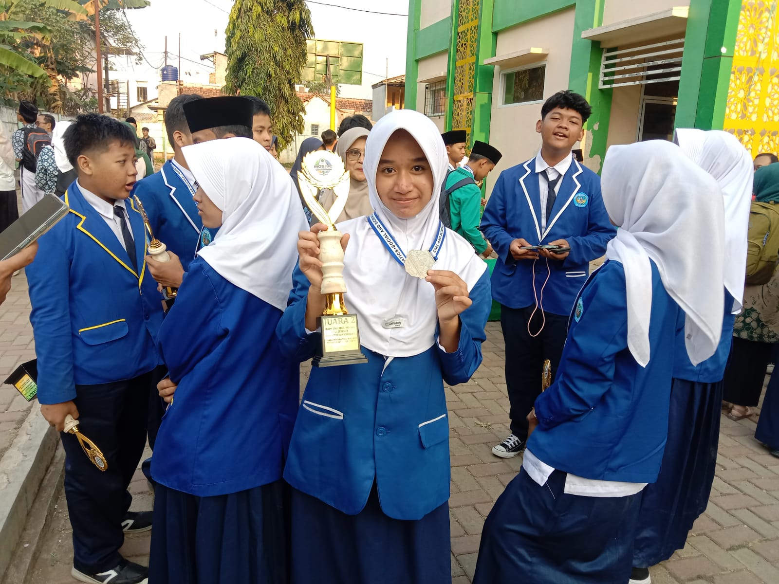 BERPRESTASI: Salah seorang siswi MTsN Kota Sukabumi menunjukkan medali dan trofi yang diraih pada ajang Madrasah Science Olympiad Competition (MASOIC) 2026 tingkat Provinsi Jawa Barat di MTsN 2 Purwakarta, Sabtu (25/7).(dok/radarsukabumi)